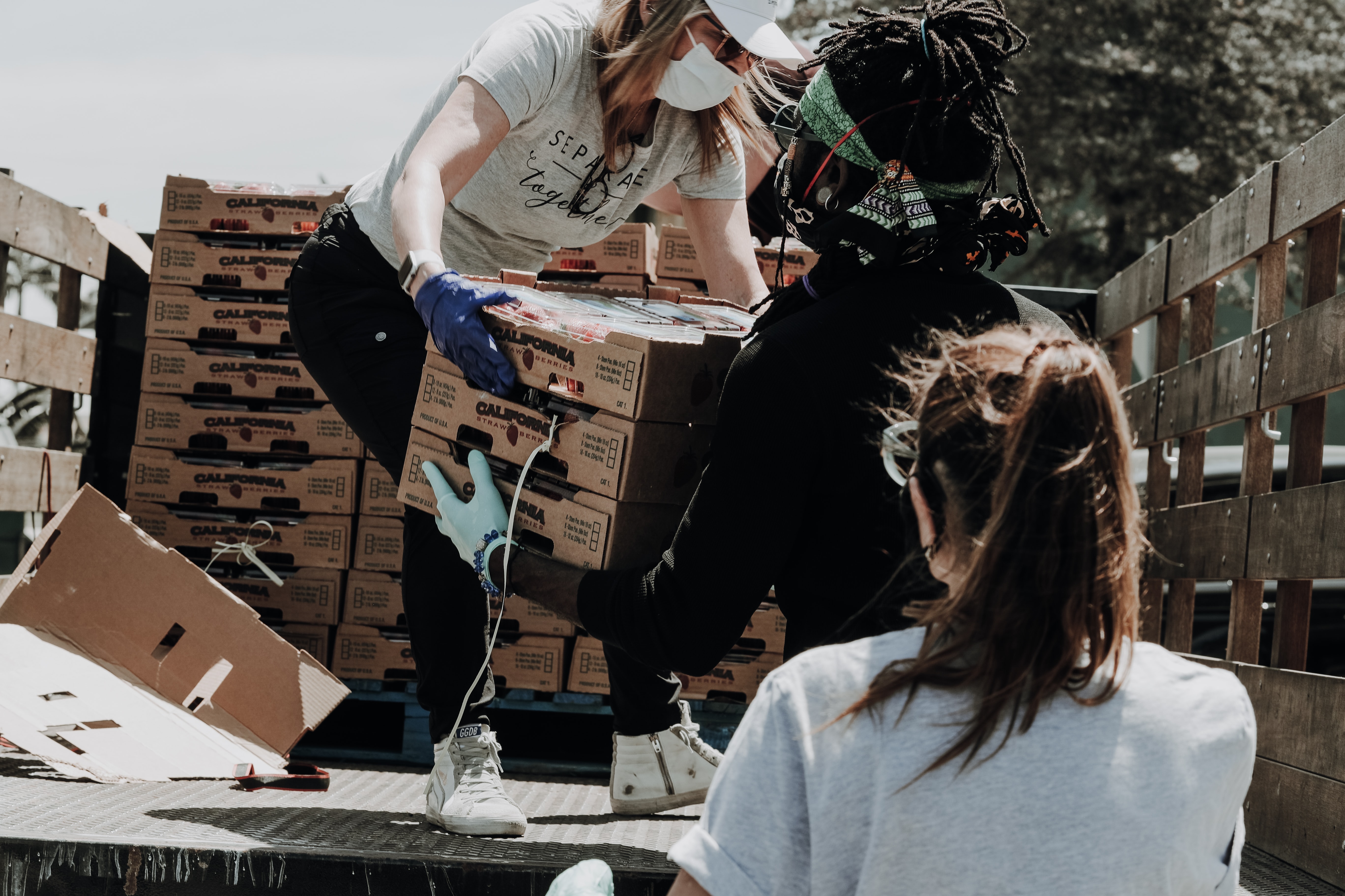 People volunteering and loading produce onto truck